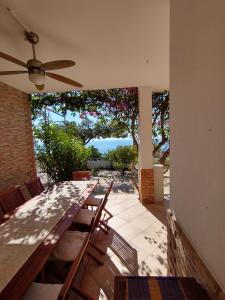 patio z krzesłami i stołem z wentylatorem sufitowym w obiekcie casa luisa3br w mieście Cala Gonone