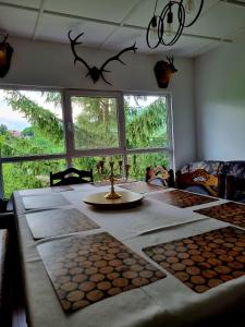 a dining room with a table with antlers on the wall at Breazary in Breaza de Jos