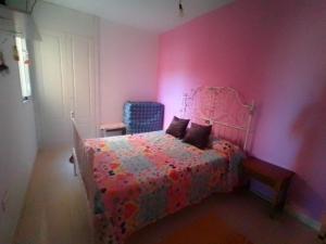 モハカルにあるApartamento Mojacar Playaのピンクのベッドルーム(ベッド1台、青い椅子付)