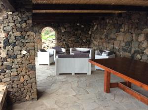 a stone walled room with a table and chairs at Dammuso Karace in Tracino