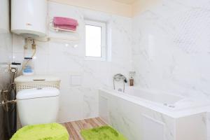 La salle de bains blanche est pourvue de toilettes et d'un lavabo. dans l'établissement Celý dům s vybavenou kuchyní, koupelna s vířivkou, à Prague