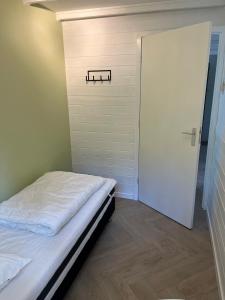 a small bedroom with a bed and a door at Villa Frederik with sauna in Winterswijk in Winterswijk