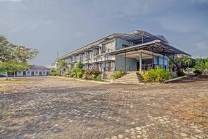 a large house with a brick road in front of it at OYO 90947 Hotel Sarbini in Menggala