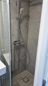 La salle de bains est pourvue d'une douche avec une porte en verre. dans l'établissement Falsterbo Guesthouse - Modern & Comfy, à Skanör med Falsterbo