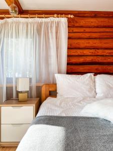 1 dormitorio con 1 cama y pared de madera en Jūras Pērle en Tūja