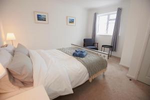 a bedroom with a large white bed and a window at 3-Bedroom bungalow with parking, Goldsithney, Penzance, Cornwall in Perranuthnoe