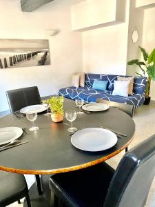 - une table à manger avec des assiettes et des verres à vin dans l'établissement APPARTEMENT PROCHE CITÈ MEDIEVALE 4 pers, à Carcassonne