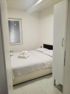 a bedroom with a bed with white sheets and a window at Villa Koki in Ohrid