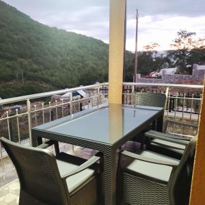 a table and chairs on a balcony with a mountain at Villa Koki in Ohrid