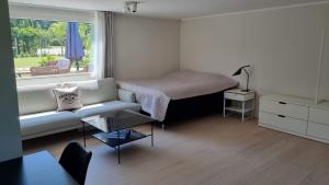 ein Wohnzimmer mit einem Sofa, einem Bett und einem Fenster in der Unterkunft Falsterbo Guesthouse - Modern & Comfy in Skanör med Falsterbo