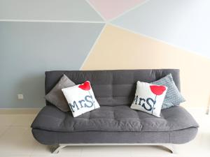 a gray couch with pillows with the word kiss on it at Medini Signature x 3min to Legoland x 2BR x 7pax in Nusajaya