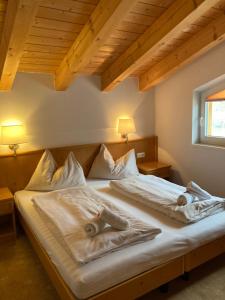 a bed in a room with two pillows on it at alpsrental Apartments Freja Obertauern in Obertauern