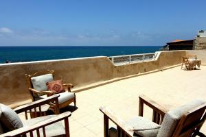 a balcony with chairs and a view of the ocean at Nzar Khoury for Hosting in ‘Akko