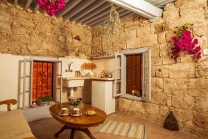 a living room with a table and a stone wall at Nzar Khoury for Hosting in ‘Akko