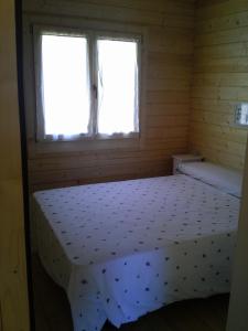 uma cama num quarto com uma janela em Arroyo de Carboneras em Brazatortas