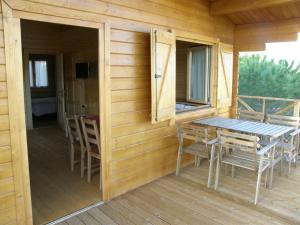 a wooden cabin with a table and chairs on a deck at Arroyo de Carboneras in Brazatortas