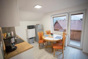 a small kitchen with a table and chairs and a window at APARTMAJI HUBI in Bled