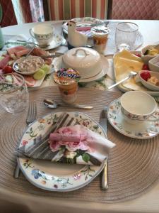 een tafel met borden en kommen met eten erop bij Pension Roseneck in Wolfshagen