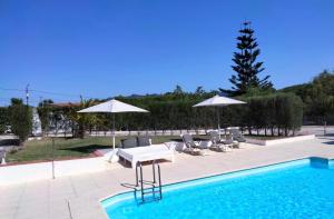 a swimming pool with umbrellas and chairs and a table and a pool at Vinha da Quinta in Sintra