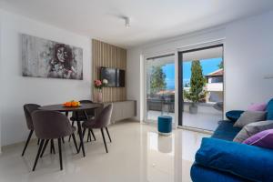 een woonkamer met een blauwe bank en een tafel bij Apartment Larissa in Njivice