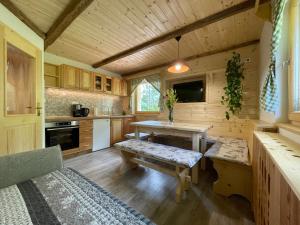 a kitchen with a table and benches in a cabin at Apartma Korošec in Srednja Vas v Bohinju