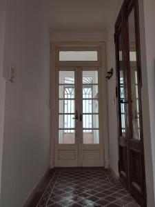 an empty hallway with a door and a window at La Emilia in San Pedro