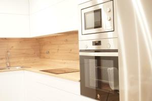una cocina con estufa y microondas en VIVIR EL MORRAZO, en Cangas de Morrazo 25 fotos más