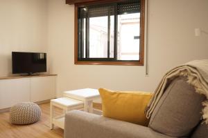 Una sala de estar con un sofá, un televisor y una mesa. en VIVIR EL MORRAZO, en Cangas de Morrazo