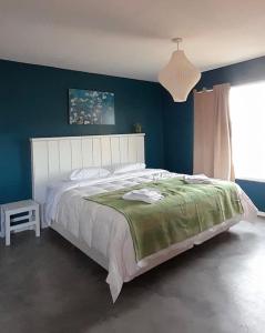 a bedroom with a large bed and a blue wall at La Azul in Dina Huapi