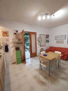 salon ze stołem i czerwoną kanapą w obiekcie casa luisa3br w mieście Cala Gonone +37 zdjęć