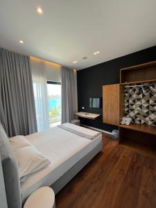1 dormitorio con 1 cama grande y escritorio en Hotel Kanes en Sarandë