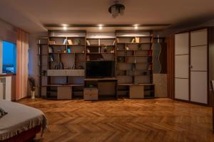 een kamer met een televisie en een boekenplank bij Old Town Home Library in Boekarest