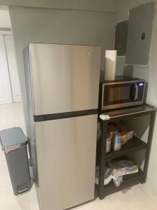 a refrigerator in a kitchen with a microwave on a shelf at Stylish Basement Studio in Central El Paso - Very spacious in El Paso