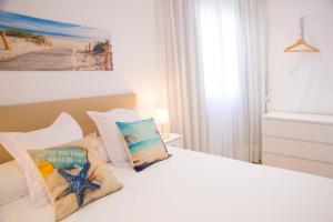 Un dormitorio con una cama blanca con almohadas. en P3 O Grove Centro Puerto, en O Grove