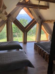 two beds in a room with a large window at Rochowa Buznica in Zakopane