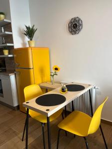 een keuken met een tafel en 2 gele stoelen bij Apartmán U Pelikána in Olomouc