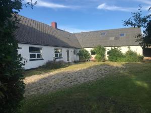 a white house with a yard in front of it at Sommerhus på Mors in Øster Assels