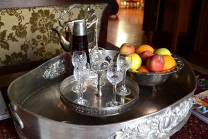 a tray with wine glasses and a bowl of fruit at A Tapestry Garden Guest House in Potchefstroom