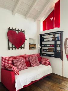 グラヴェドーナにあるCa' Storta una romantica baita fra i montiの壁に心臓を付けた部屋の赤いソファ