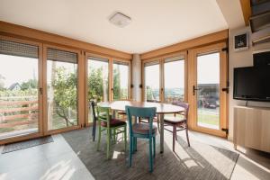 a dining room with a table and chairs and windows at Kuća za odmor Vlahek in Grabrovnik
