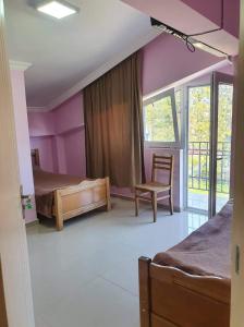 una camera da letto con pareti viola, un letto e una sedia di Hotel Lotus a Ureki