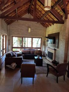 uma sala de estar com um sofá e uma lareira em Pousada Bucaneve em Monte Verde