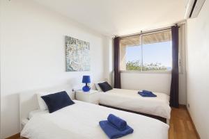 two beds in a room with a window at Vila Olimpica Skyline in Barcelona