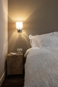a bedroom with a bed and a lamp at Cozy Boutique B&B De Roos & Garden Lounge in Leeuwarden
