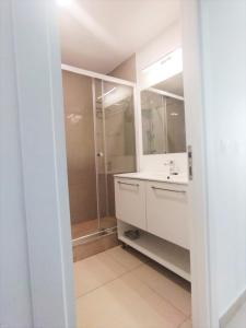 ein weißes Badezimmer mit Waschbecken und Dusche in der Unterkunft Mediterranean Apartments at Blaxy, Olimp in Olimp + 11 Fotos