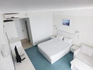 ein weißes Schlafzimmer mit einem Bett und einer Couch in der Unterkunft Mediterranean Apartments at Blaxy, Olimp in Olimp