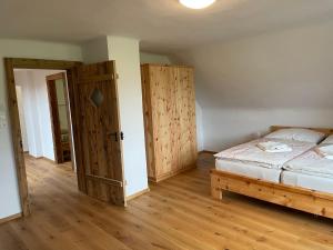 Schlafzimmer mit einem Bett und einer Holztür in der Unterkunft Landhaus Waisenegg 