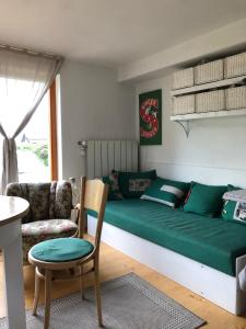 a living room with a green bed and a chair at Apartmán LUČA in Liptovský Mikuláš
