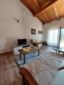 ein Wohnzimmer mit einem Couchtisch und einem TV in der Unterkunft Apartman Boljević in Podgorica