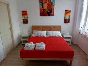 Un dormitorio con una cama roja con dos zapatos. en Affittacamere Il Chiostrino Guest House, en Florencia